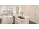 Open-concept kitchen island with stainless steel sink and dishwasher connecting to the living area at 10331 E 62Nd Pl, Denver, CO 80238