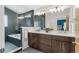 Sleek bathroom featuring a glass-enclosed shower and tub, dual vanity with modern fixtures, and stylish tiles at 4511 Meade St, Denver, CO 80211