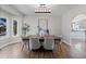 Elegant dining room with a modern chandelier and views of the yard through a large window at 7071 S Gibraltar Way, Centennial, CO 80016