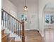 Inviting foyer featuring hardwood floors, staircase, and an arched doorway to the living spaces at 7071 S Gibraltar Way, Centennial, CO 80016