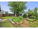 Backyard featuring stone pathway, raised garden beds, mature trees, and a shed creating an outdoor oasis at 4673 Bryant St, Denver, CO 80211
