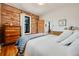 Cozy bedroom with exposed brick wall, hardwood floors, and warm natural light at 4673 Bryant St, Denver, CO 80211