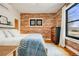 Inviting bedroom with exposed brick wall, hardwood floors, and a large window showcasing the neighborhood at 4673 Bryant St, Denver, CO 80211