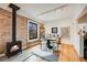 Dining area with a modern wood burning stove, exposed brick, and a round dining table at 4673 Bryant St, Denver, CO 80211