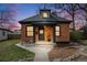 Charming brick home featuring a cozy front porch and manicured lawn at dusk at 4673 Bryant St, Denver, CO 80211