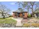 Charming brick home featuring a cozy front porch and manicured lawn at 4673 Bryant St, Denver, CO 80211