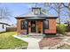 Charming brick home featuring a cozy front porch and manicured lawn at 4673 Bryant St, Denver, CO 80211