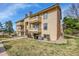 Inviting condo building featuring balconies, neutral siding, mature trees, and well-maintained landscaping at 420 Zang St # 108, Lakewood, CO 80228