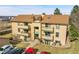 Exterior view of a three-story apartment complex with balconies and well-maintained landscaping at 420 Zang St # 108, Lakewood, CO 80228