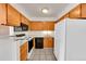 Efficient kitchen with wood cabinets, white appliances, and tile flooring for easy maintenance at 420 Zang St # 108, Lakewood, CO 80228