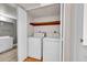 Convenient laundry closet with washer and dryer, wood shelving and close access to bathroom at 420 Zang St # 108, Lakewood, CO 80228