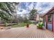 Spacious backyard with deck, patio furniture, and landscaped area at 11838 W Arlington Dr, Littleton, CO 80127