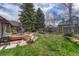 This fenced backyard features a large grassy lawn with mature trees at 11838 W Arlington Dr, Littleton, CO 80127