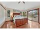 Comfortable bedroom with hardwood floors, a king-sized bed, natural light, and access to outdoor deck at 11838 W Arlington Dr, Littleton, CO 80127