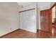 Bedroom featuring wood floors, closet with sliding doors, and neutral paint at 11838 W Arlington Dr, Littleton, CO 80127