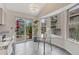 Cozy breakfast nook with glass table, bright windows, and sliding glass doors leading to the patio at 11838 W Arlington Dr, Littleton, CO 80127