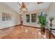 Sunny dining room with hardwood floors, modern lighting, and large windows offering views of the backyard at 11838 W Arlington Dr, Littleton, CO 80127