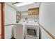 Laundry room with washer, dryer, cabinets, and a shelf at 11838 W Arlington Dr, Littleton, CO 80127