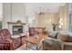 Spacious living room with a fireplace, hardwood floors, and views of the upper level at 11838 W Arlington Dr, Littleton, CO 80127