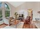 Cozy living room featuring large windows, hardwood floors, and a fireplace at 11838 W Arlington Dr, Littleton, CO 80127