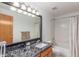 Well-lit bathroom with granite counters, a large mirror, and shower-tub combination at 11256 Lima St, Commerce City, CO 80640