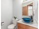 Stylish bathroom featuring a unique blue glass vessel sink and a matching mirror at 11256 Lima St, Commerce City, CO 80640
