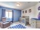Charming Bedroom with blue accent wall, crib, rocking chair, and ample natural light at 11256 Lima St, Commerce City, CO 80640