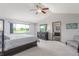 Bright main bedroom with large window, a ceiling fan, and an ensuite bathroom at 11256 Lima St, Commerce City, CO 80640