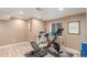 Home gym in the basement with wood floors and space for a stationary bike and workout bench at 11256 Lima St, Commerce City, CO 80640
