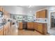 Open kitchen with wood cabinets, granite countertops, stainless steel appliances, and an adjacent dining area at 11256 Lima St, Commerce City, CO 80640