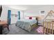Sunlit bedroom features a plush bed, desk, crib, and bright blue curtains at 16423 Mountain Flax Dr, Monument, CO 80132