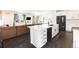 Open-concept kitchen with sleek, modern white cabinets, black appliances, and a large island at 16423 Mountain Flax Dr, Monument, CO 80132