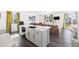 Stylish open concept kitchen with white cabinets, dark wood floors, and a large island at 16423 Mountain Flax Dr, Monument, CO 80132