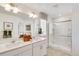 Bright bathroom features a double sink vanity, framed mirror, and glass shower at 779 N Deer Park St, Watkins, CO 80137