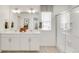 Bright bathroom features a double sink vanity, framed mirror, and glass shower at 779 N Deer Park St, Watkins, CO 80137