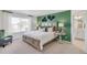 Well-lit bedroom showcasing a plush bed, modern decor, decorative green wall, and a tranquil ambiance at 779 N Deer Park St, Watkins, CO 80137
