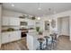 Open kitchen with white cabinets, granite countertops, stainless appliances, and a center island with seating at 779 N Deer Park St, Watkins, CO 80137