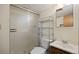 Bathroom with a frosted glass shower door, toilet, shelving unit, and wooden sink vanity at 5808 E Hinsdale Pl, Centennial, CO 80112