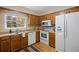 Well-maintained kitchen with wood cabinets, white appliances, and hardwood floors at 5808 E Hinsdale Pl, Centennial, CO 80112