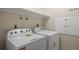 Practical laundry room with modern washer and dryer units, and overhead storage at 5808 E Hinsdale Pl, Centennial, CO 80112