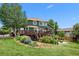 Expansive backyard featuring a wooden deck, fire pit, lush landscaping, and mature trees at 603 E 2Nd Ave, Castle Rock, CO 80108
