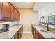 Basement wet bar with dark wood cabinetry, granite counters, and a stainless sink at 11938 S Meander Way, Parker, CO 80138