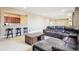 Open finished basement has a wet bar with dark wood cabinets and barstool seating at 11938 S Meander Way, Parker, CO 80138
