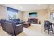 Basement with a leather sofa, TV, fireplace, and bar seating for entertaining at 11938 S Meander Way, Parker, CO 80138