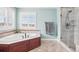 Well-lit bathroom showcasing a garden tub, glass-enclosed shower, and neutral tiling throughout at 11938 S Meander Way, Parker, CO 80138