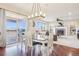 Bright dining area with hardwood floors, stylish lighting fixture, and access to an outdoor deck at 11938 S Meander Way, Parker, CO 80138