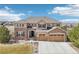 Inviting two-story home featuring a three car garage, stone accents, and manicured landscaping at 11938 S Meander Way, Parker, CO 80138