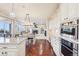 Open concept kitchen with sleek appliances, stone countertops and a clear view to the living room at 11938 S Meander Way, Parker, CO 80138