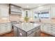 Gourmet kitchen with gray cabinets, granite countertops, stainless steel appliances and center island at 11938 S Meander Way, Parker, CO 80138