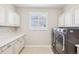 Well-equipped laundry room with ample storage cabinets and a modern washer and dryer at 11938 S Meander Way, Parker, CO 80138